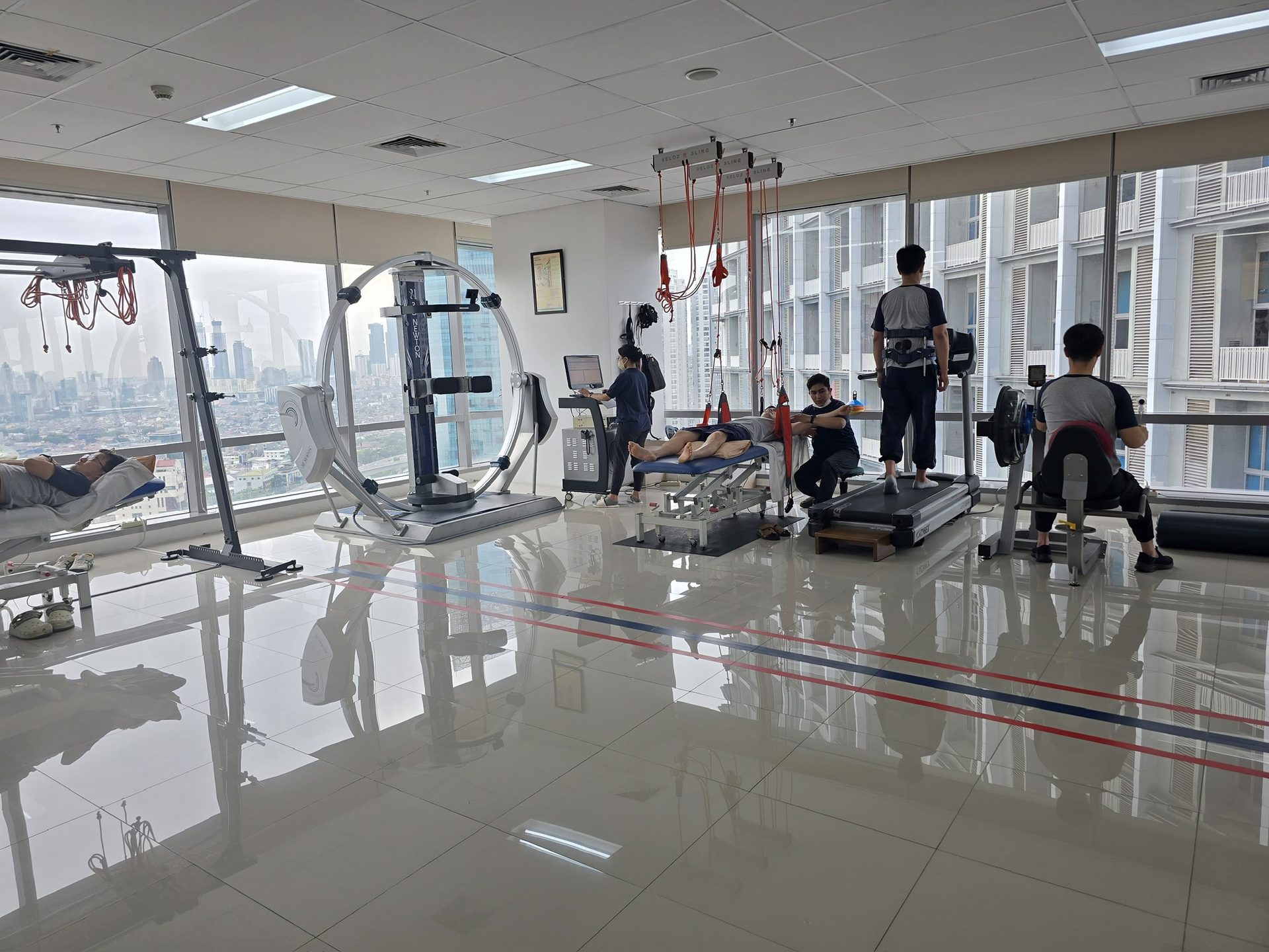 Therapists treating patients at the SW rehabilitation center, with a view over Jakarta